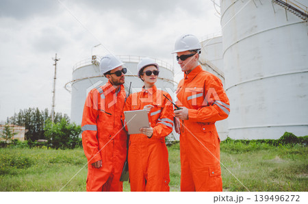Field engineers reviewing inspection data and coordinating maintenance at oil storage tanks Field engineers reviewing inspection data and coordinating maintenance at oil storage tanks 139496272