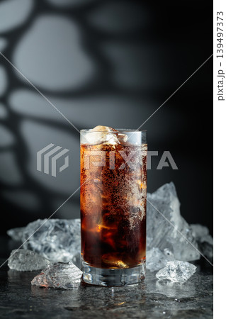 Cola with ice in misted glass on a black stone table. 139497373