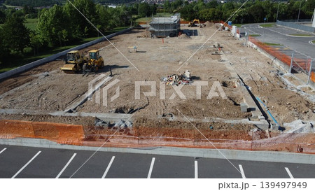 Aerial view of a construction site with heavy machinery and building foundations under development. 139497949