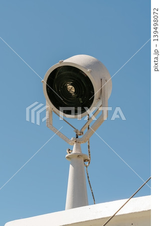Ship searchlight on vessel against blue sky Ship searchlight on vessel against blue sky 139498072