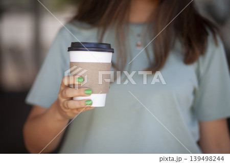 Woman Holding Takeaway Coffee Cup. Young Woman with Takeaway Coffee in Hand. Woman Holding Takeaway Coffee Cup. Young Woman with Takeaway Coffee in Hand. 139498244