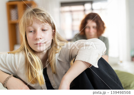 Teenager expressing sadness ignoring mother's presence at home Teenager expressing sadness ignoring mother's presence at home 139498508