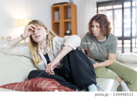 Mother talking with stressed teenage girl at home Mother talking with stressed teenage girl at home 139498511