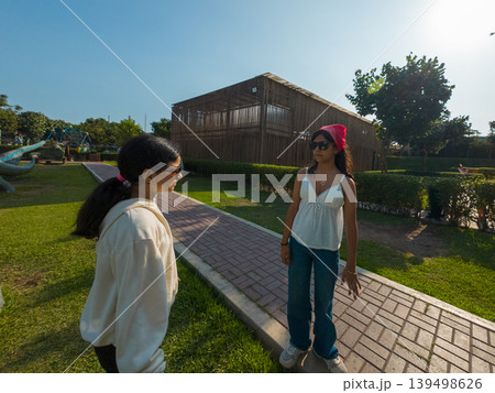 Two women are walking down a path in a park 139498626