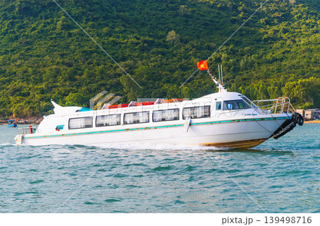 White tourist speedboat sails through sea near an island in Vietnam. Motor boat in river in Asia White tourist speedboat sails through sea near an island in Vietnam. Motor boat in river in Asia 139498716