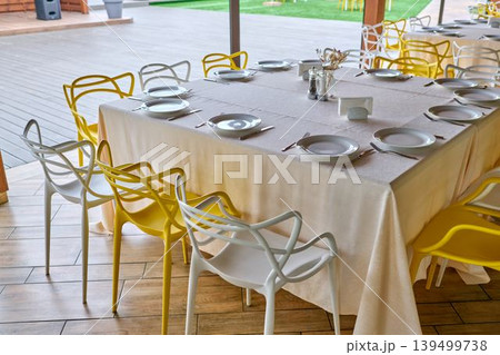 Restaurant dining area with yellow and white chairs. 139499738