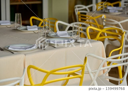 Bright dining setting with moden the table is a row of modern chairs, white tones for the event. Bright dining setting with moden the table is a row of modern chairs, white tones for the event. 139499768