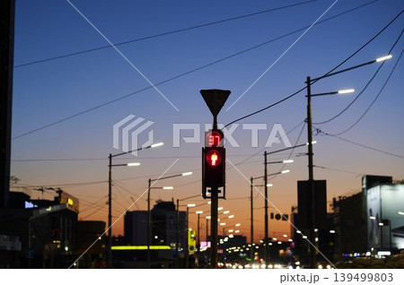 City lights twinkle as dusk settles on a bustling street, signaling twilight's arrival 139499803
