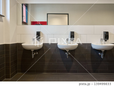 Contemporary Public Restroom Sinks with Dark White Tile. Contemporary Public Restroom Sinks with Dark White Tile. 139499833