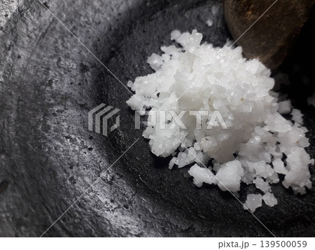 White Salt Crystals on Black Clay Mortar with Copy Space on Left 139500059