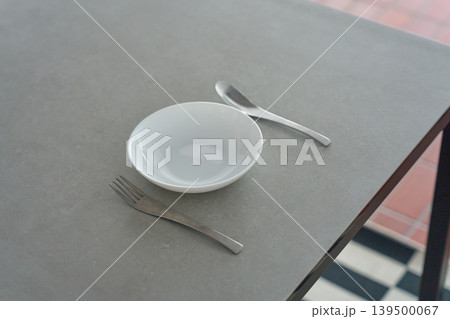 テーブルの上に置かれた白い食器とカトラリー 139500067