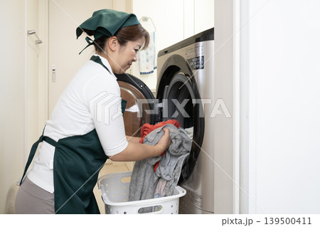 洗濯物を入れる家事代行の女性 洗濯物を入れる家事代行の女性 139500411