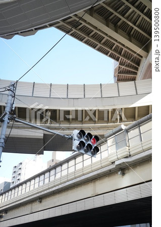青空を背景に幾重にも交差する高速道路の高架と赤信号 青空を背景に幾重にも交差する高速道路の高架と赤信号 139500800