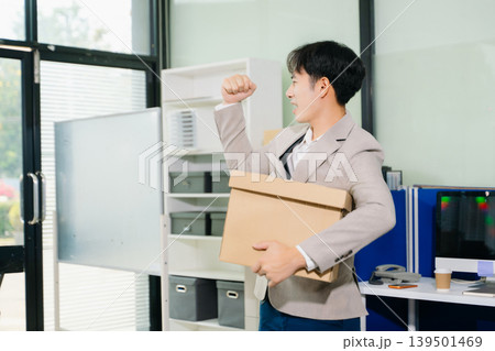 Happy and excited young man office worker celebrating her resignation, carrying her personal stuff. leaving job, changing or company. Happy and excited young man office worker celebrating her resignation, carrying her personal stuff. leaving job, changing or company. 139501469