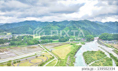 曇天の五月、雨が降り出しそうな黒部川扇状地と愛本橋や公園などの周辺の施設の様子 139502334