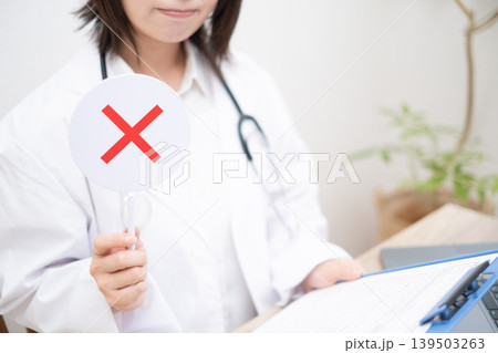 不正解の札を出す女性のお医者さん 139503263