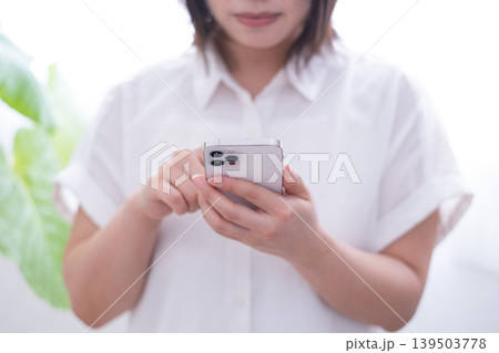 スマートフォンを操作する女性(正面) スマートフォンを操作する女性(正面) 139503778