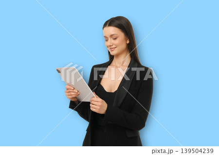 Woman works on tablet in blank blue background space Woman works on tablet in blank blue background space 139504239