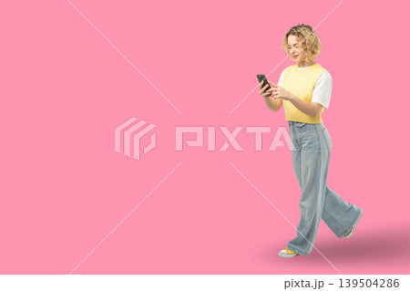 Woman walks and uses mobile gadget in a bright setting Woman walks and uses mobile gadget in a bright setting 139504286