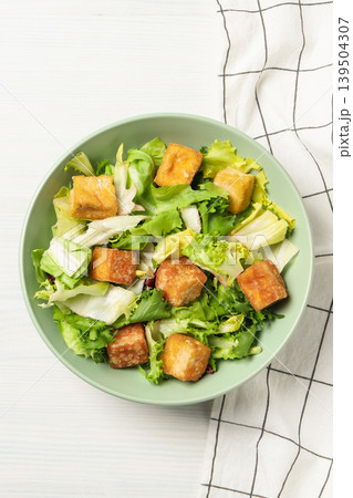 Crisp greens and tofu chunks arranged in a bowl Crisp greens and tofu chunks arranged in a bowl 139504307