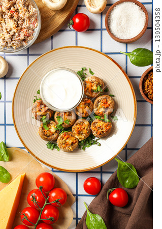 Stuffed mushrooms arranged on a plate with sauce and vegetables Stuffed mushrooms arranged on a plate with sauce and vegetables 139504358