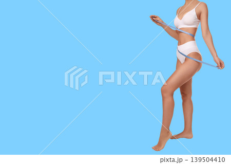Female model measures waistline while promoting body care tips 139504410