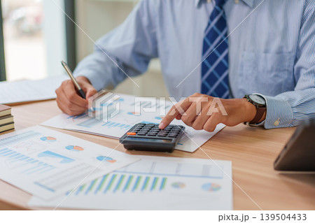 Asian Male 30-40s Real Estate Agent Analyzing Market Charts in Thailand Office Asian Male 30-40s Real Estate Agent Analyzing Market Charts in Thailand Office 139504433