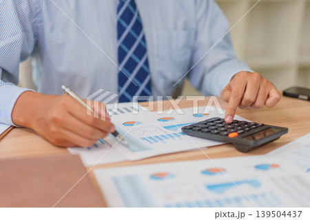 Asian Male 30-40s Real Estate Agent Analyzing Market Charts in Thailand Office Asian Male 30-40s Real Estate Agent Analyzing Market Charts in Thailand Office 139504437