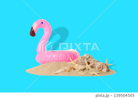 Flamingo float resting on sand with seashells nearby Flamingo float resting on sand with seashells nearby 139504505
