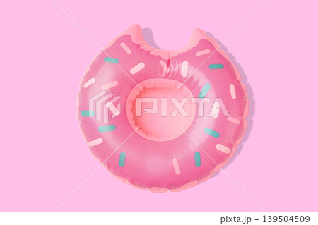 Pink donut-shaped float ready for summer activities in water Pink donut-shaped float ready for summer activities in water 139504509