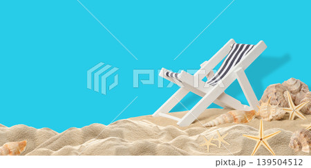 White beach chair on sand with seashells and starfish nearby 139504512