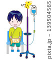 椅子に座って左腕に点滴をしている子供　笑顔で本を立てて読んでいるイメージ 139504565