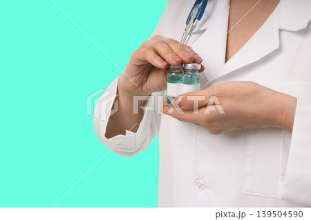 A healthcare worker readies a vaccine vial for use 139504590