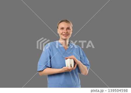 Dental expert demonstrates a tooth model with a smile Dental expert demonstrates a tooth model with a smile 139504598