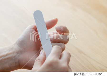 女性がネイルファイルで手の爪の手入れをしている 139504846