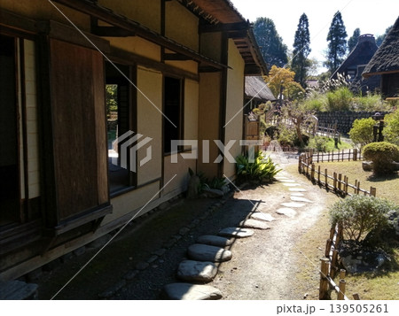 茅葺き屋根の古民家が並ぶ日本の原風景と庭園の飛び石 茅葺き屋根の古民家が並ぶ日本の原風景と庭園の飛び石 139505261
