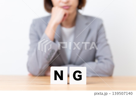 NGのブロックと悩むスーツ姿のミドル女性 NGのブロックと悩むスーツ姿のミドル女性 139507140