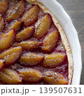 Freshly baked homemade plum tart with caramelized fruit slices in a white ceramic mold. Delicious seasonal dessert 139507631