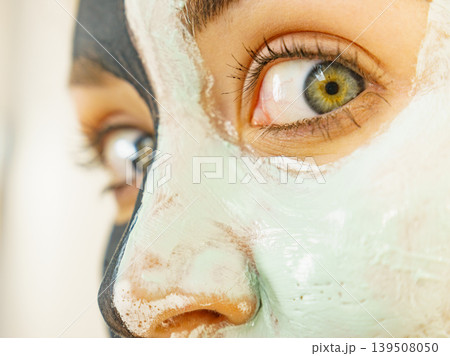 Girl black and green mud mask on face Girl black and green mud mask on face 139508050