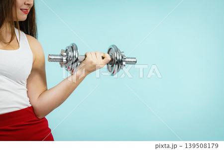Woman lifting dumbbells 139508179