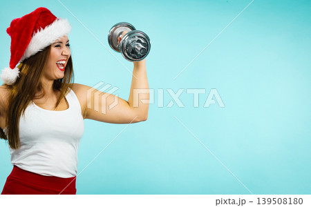 Santa claus woman lifting dumbbells Santa claus woman lifting dumbbells 139508180