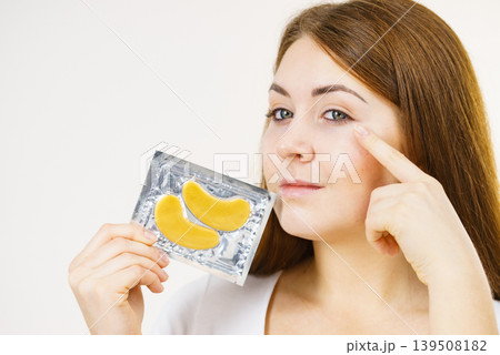 Woman ready to apply gold eye patches Woman ready to apply gold eye patches 139508182