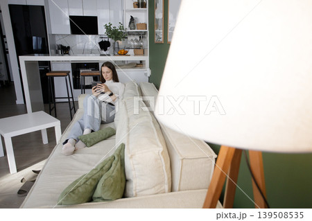 Cute woman using digital reader electronic book at home. Beautiful model with long hair 139508535