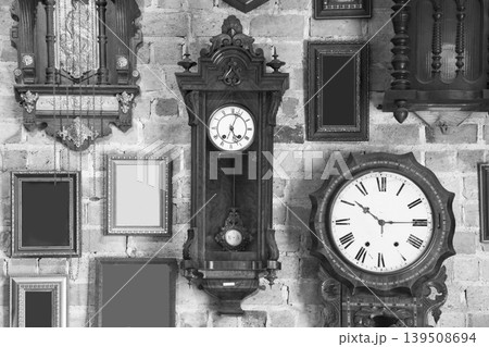 Monochrome vintage clock and picture frame hanging on an brick wall Monochrome vintage clock and picture frame hanging on an brick wall 139508694