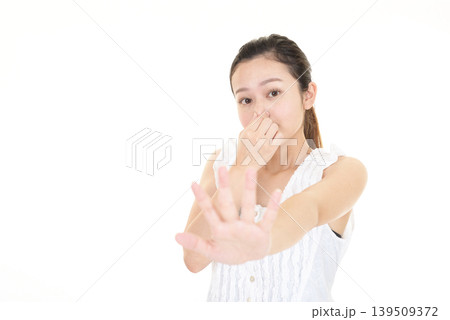 鼻を抑えてストップのジェスチャーをする女性 139509372