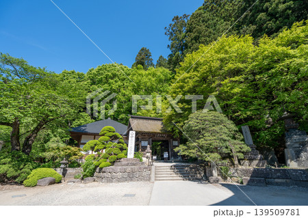 山形・山寺の手入れされた松の木と石灯籠がある日本の寺院建物 139509781