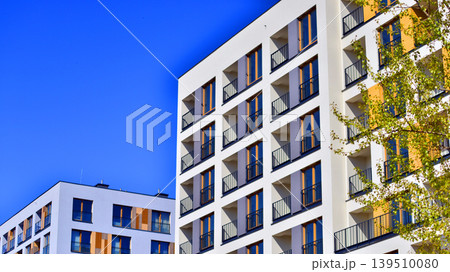 European residential architecture harmonizing with nature. Eco-friendly living in city with greens. Eco apartment building saving energy and fresh air concept. European residential architecture harmonizing with nature. Eco-friendly living in city with greens. Eco apartment building saving energy and fresh air concept. 139510080