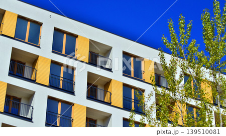 European residential architecture harmonizing with nature. Eco-friendly living in city with greens. Eco apartment building saving energy and fresh air concept. European residential architecture harmonizing with nature. Eco-friendly living in city with greens. Eco apartment building saving energy and fresh air concept. 139510081