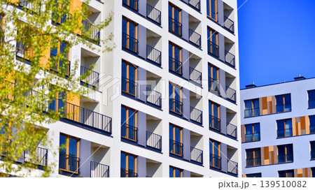 European residential architecture harmonizing with nature. Eco-friendly living in city with greens. Eco apartment building saving energy and fresh air concept. European residential architecture harmonizing with nature. Eco-friendly living in city with greens. Eco apartment building saving energy and fresh air concept. 139510082