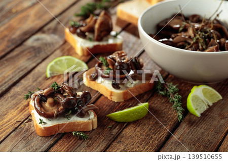 Sandwiches with baked mushrooms on an old wooden table. 139510655